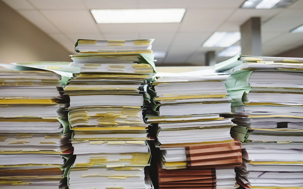 Tall stacks of paper files in an office