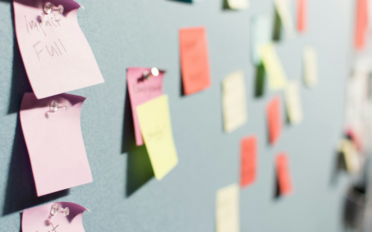Colorful sticky notes pinned to a grey board