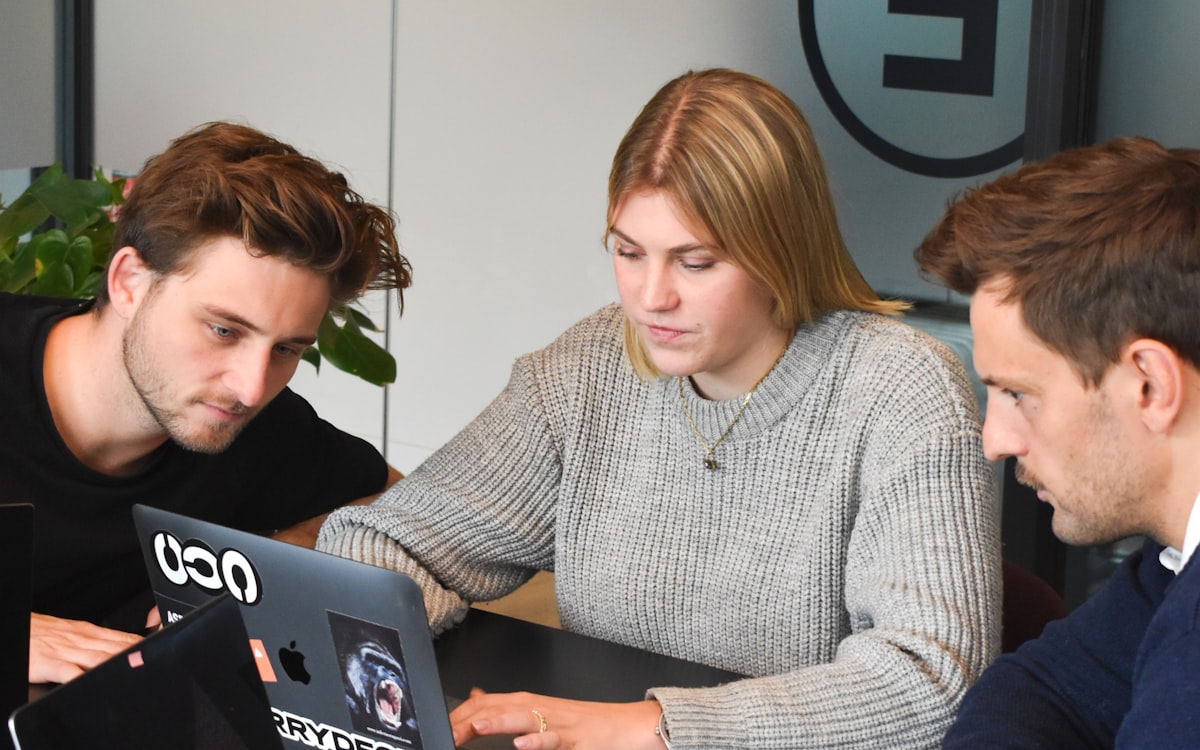 Three colleagues working together on a laptop